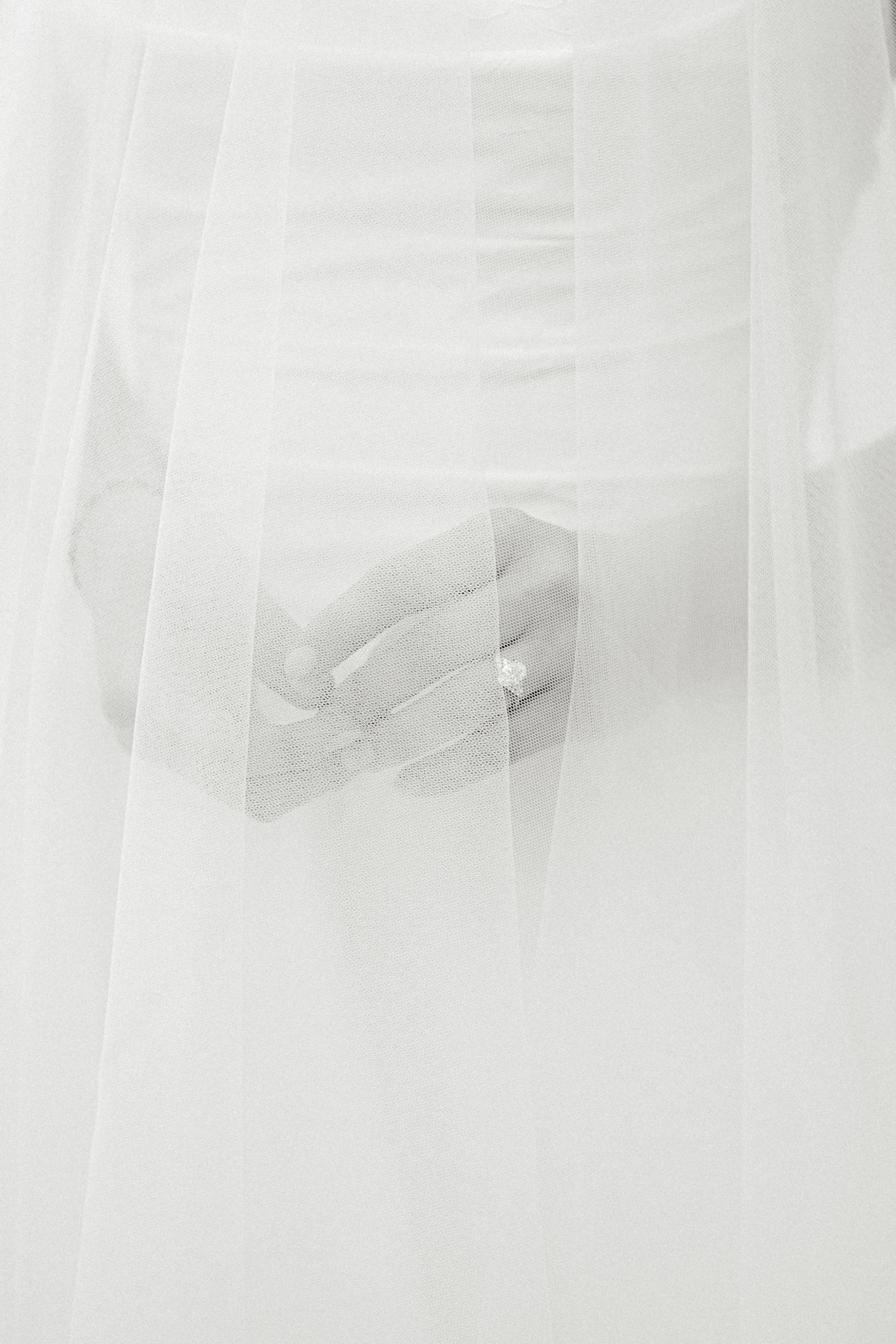 Hands with wedding ring under veil