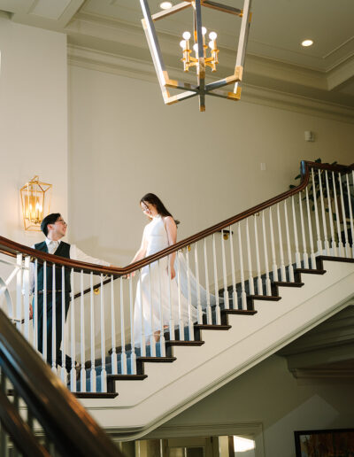 Groom leading Bride walking down stairs