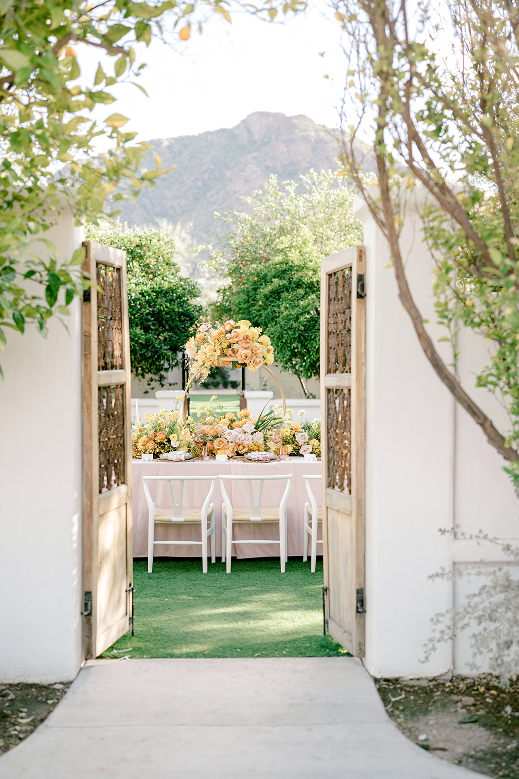 wedding table set with yellow and peach colors looking through gate doors