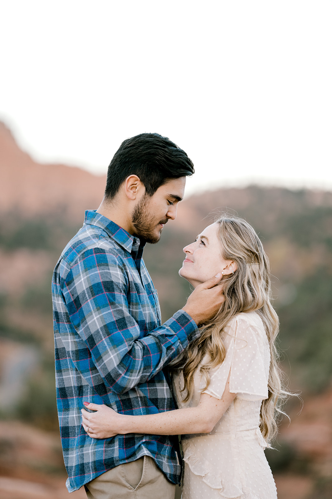 guy holding girls jaw while they look at each other